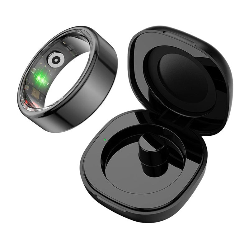 Bague connectée noire COLMi R02 ouverte sur son électronique, posée à côté de son boîtier de charge